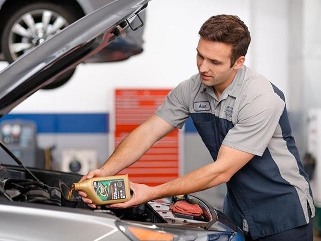 A Person Changing Oil of A Vehicle